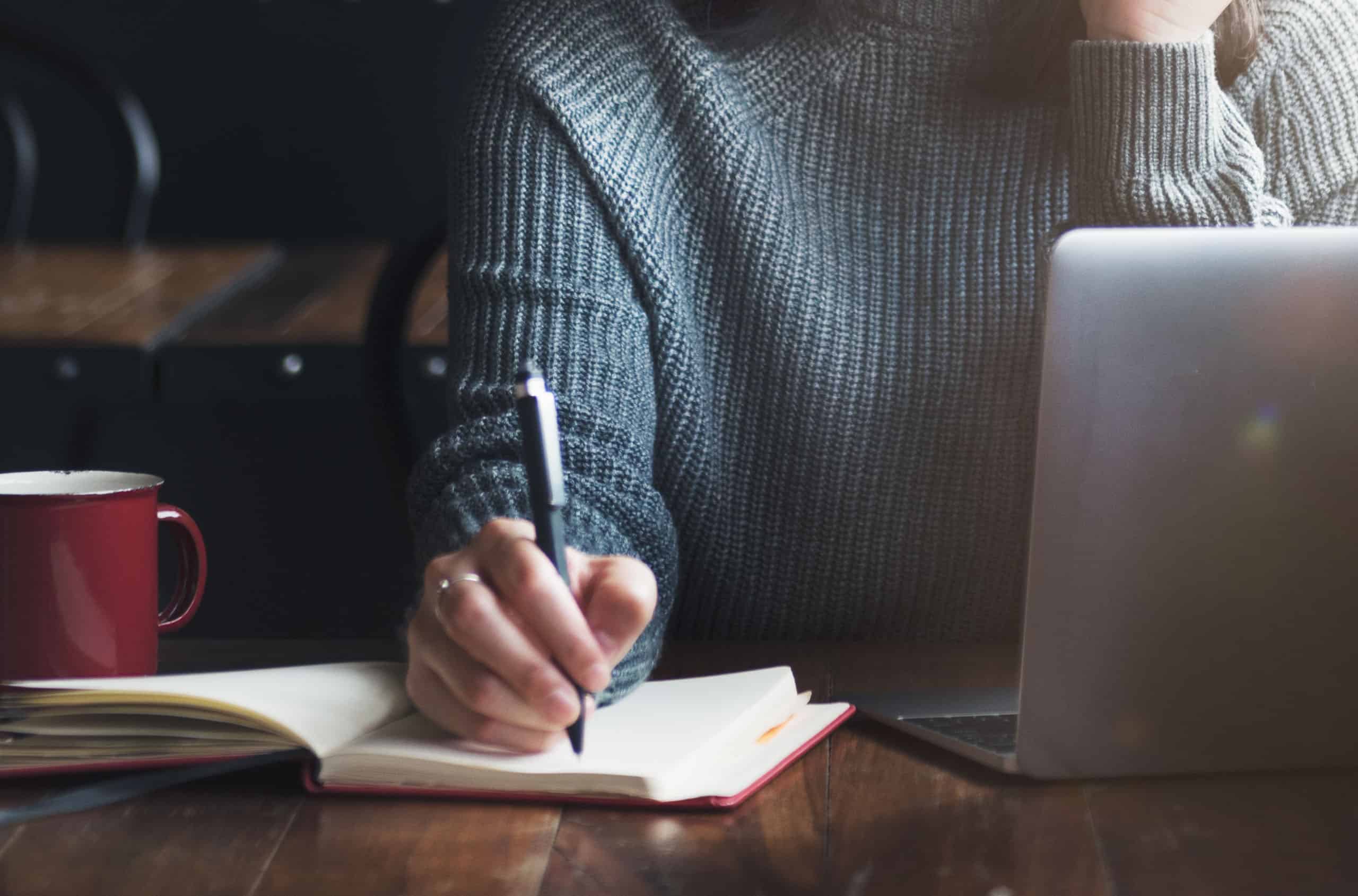 A person taking notes in a notebook.
