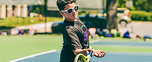 A boy playing tennis.