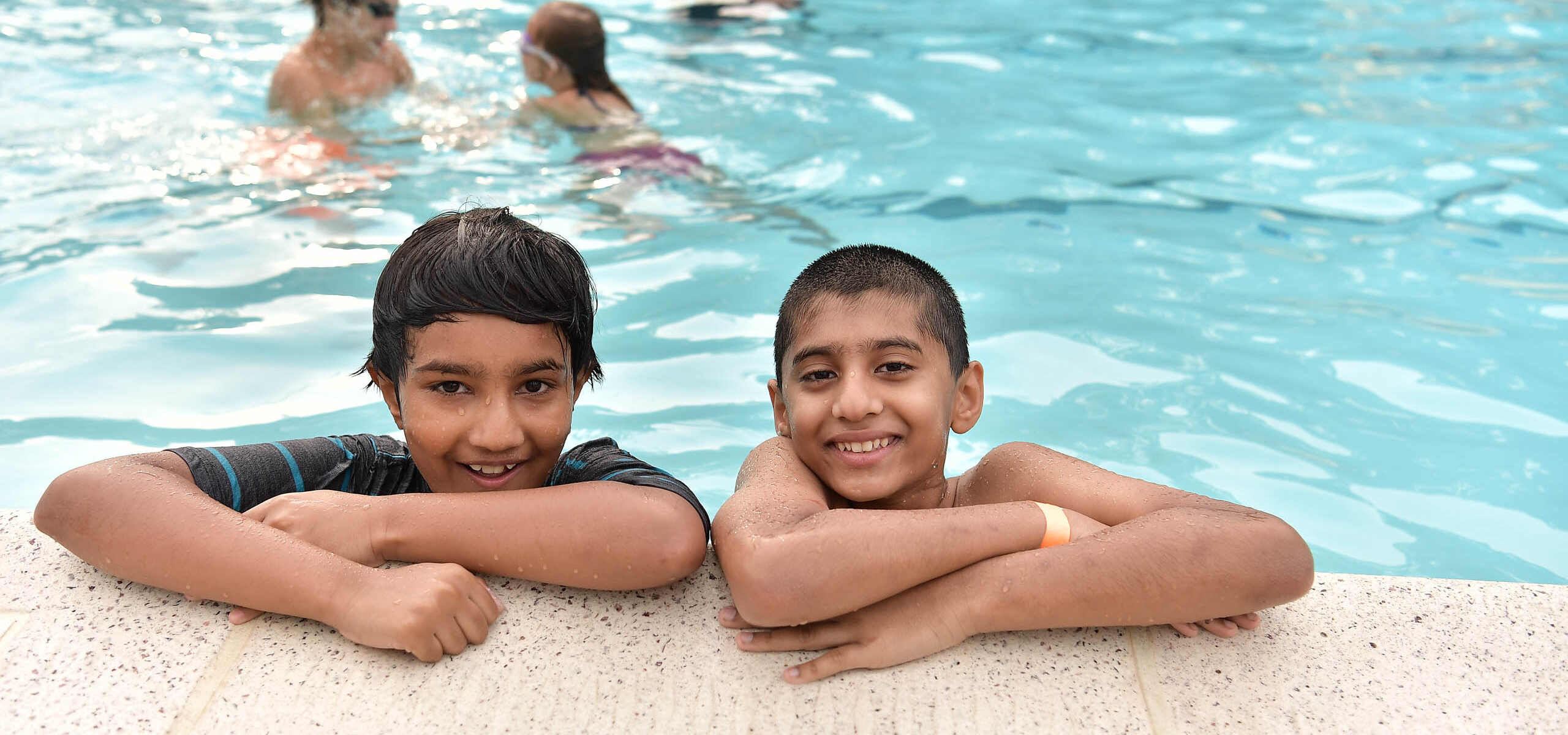 Two kids at a swimming pool.