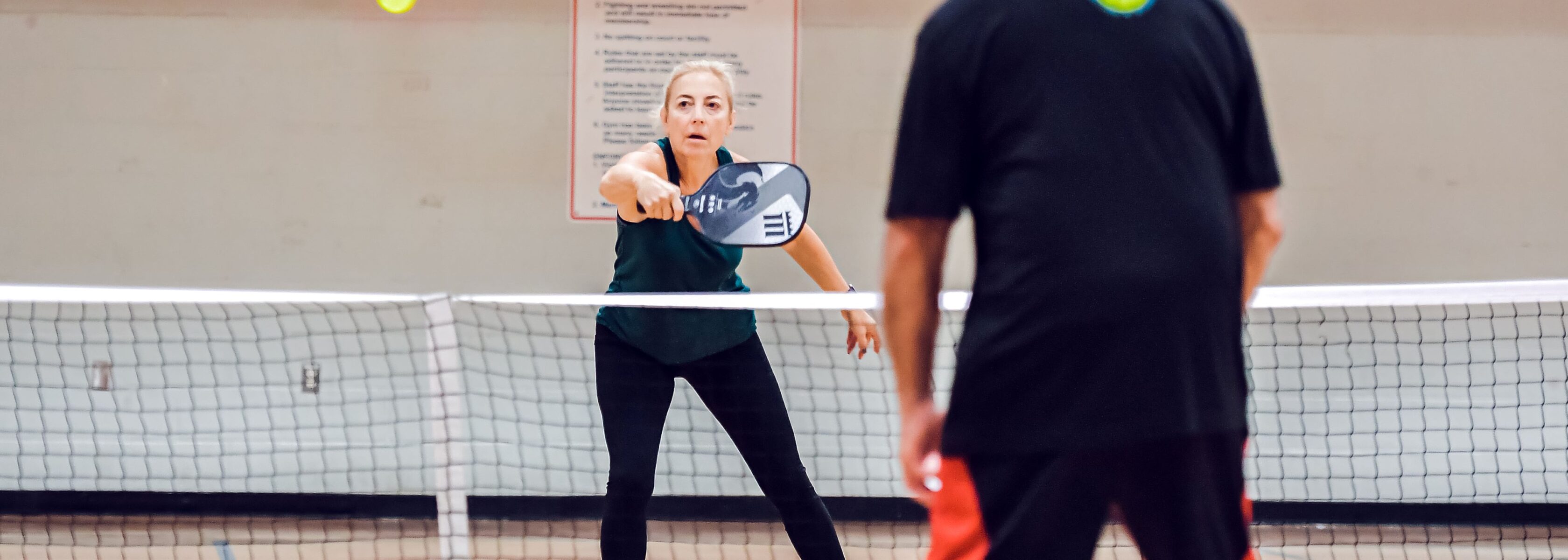 Two adults playing pickleball.