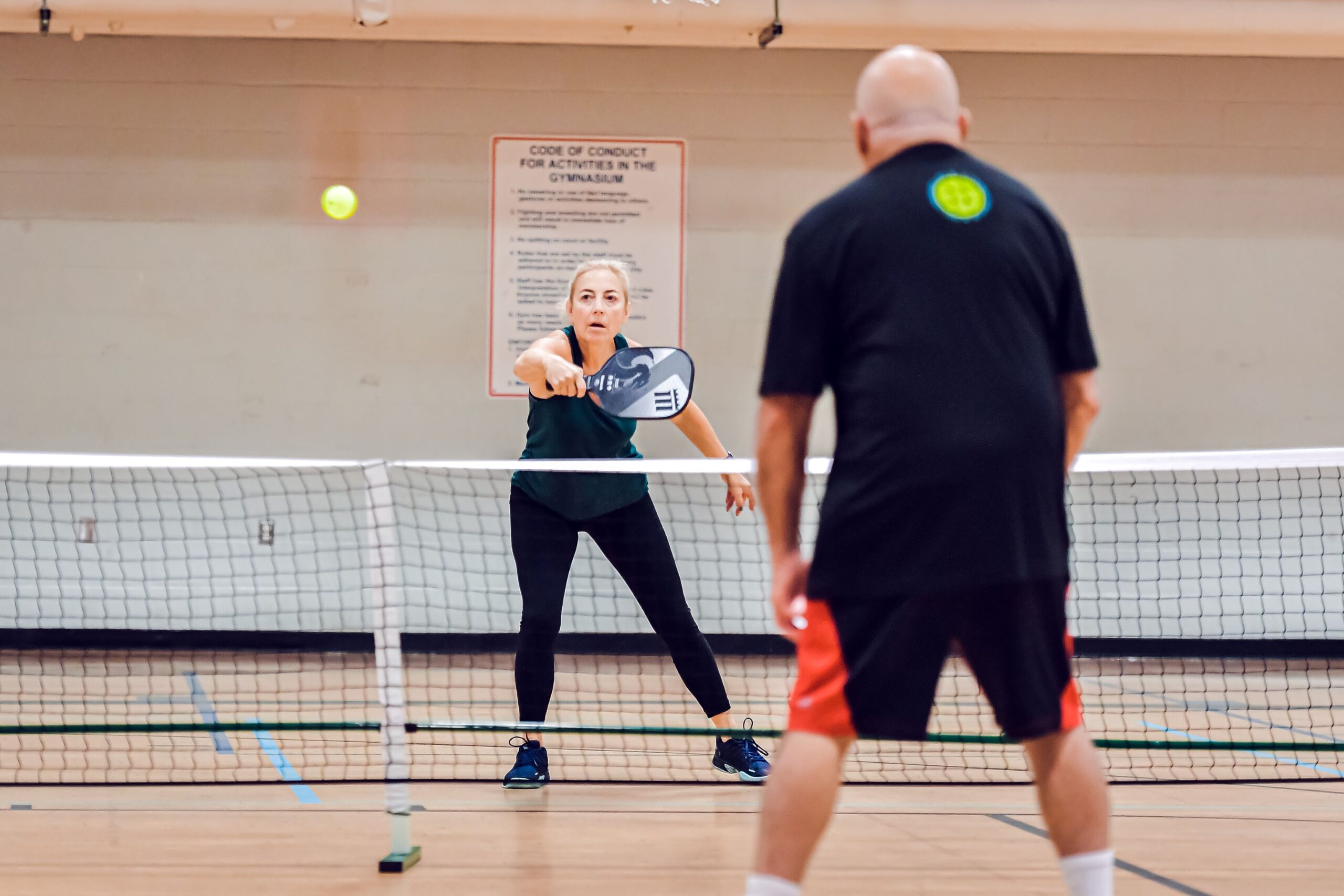 Two adults playing pickleball.