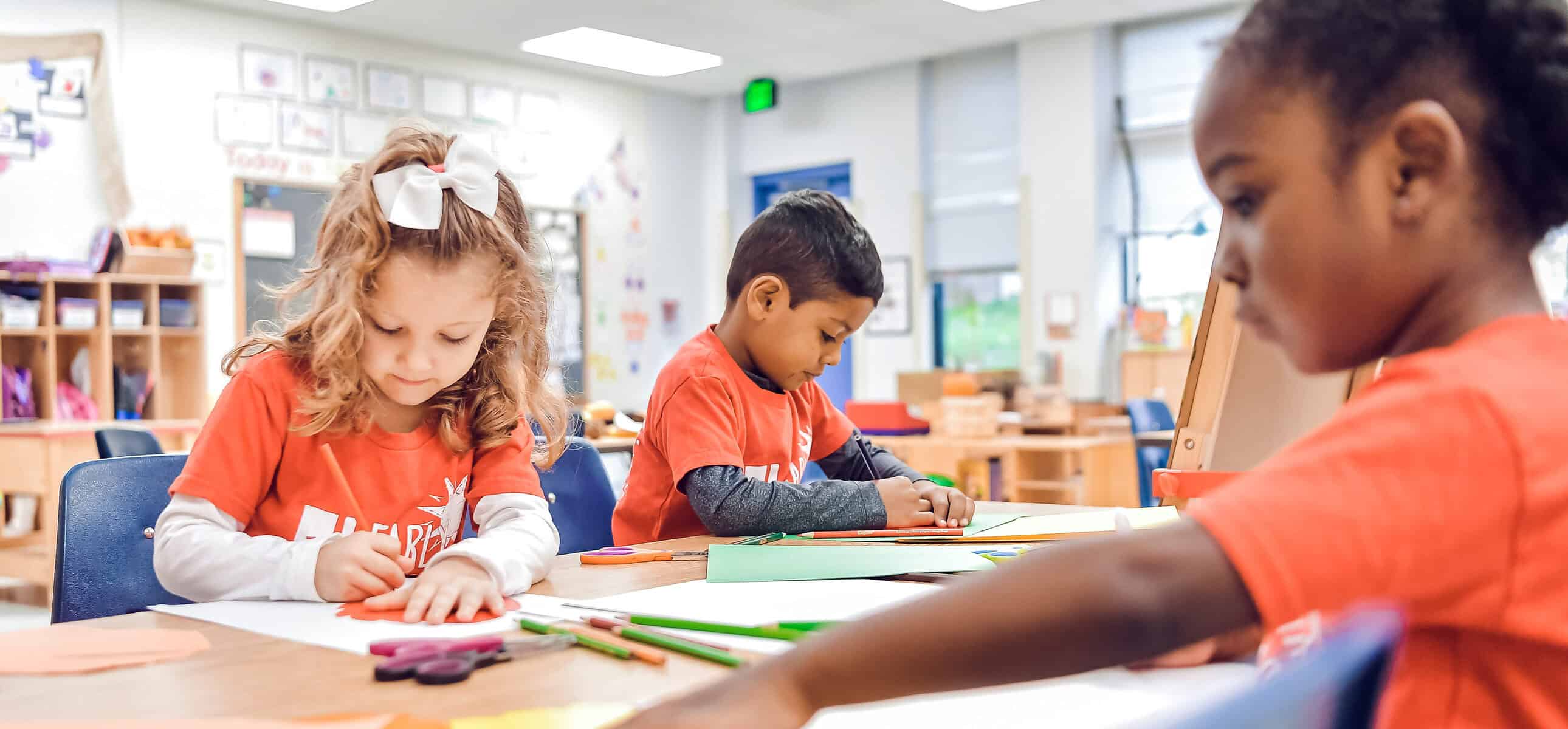 preschool children at desks in classroom