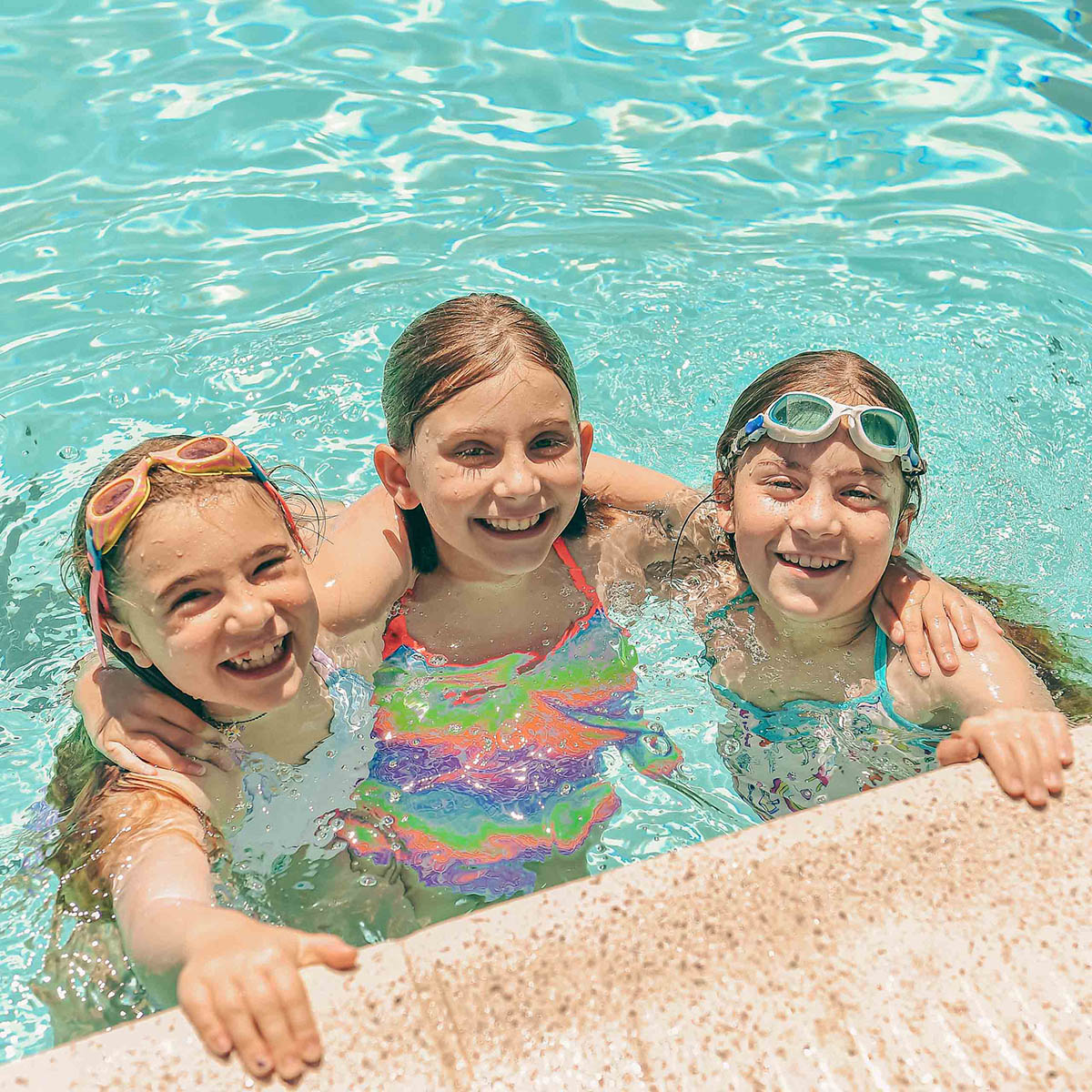 Three campers in a swimming pool.