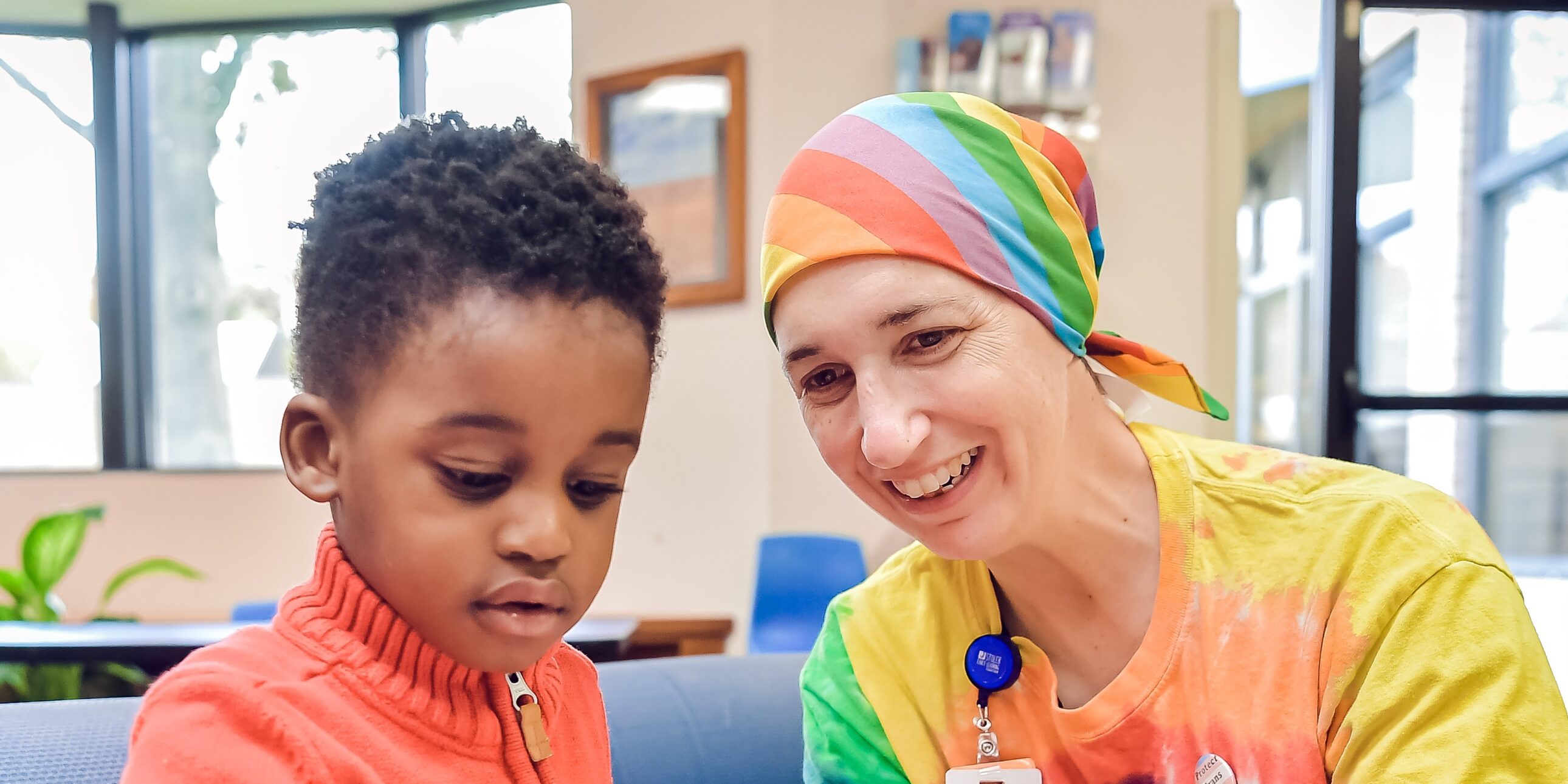 A staff member reading a book to a child.