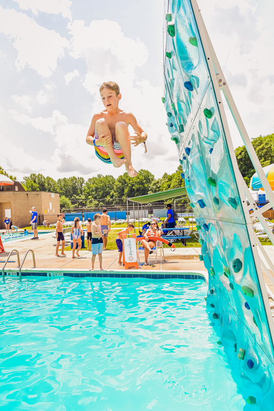 A kid jumping into a pool.