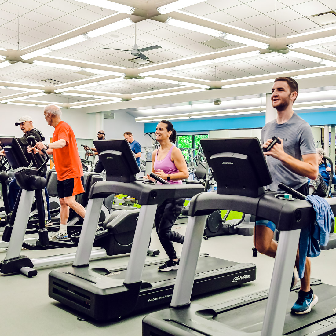 People running on treadmills in a fitness center.