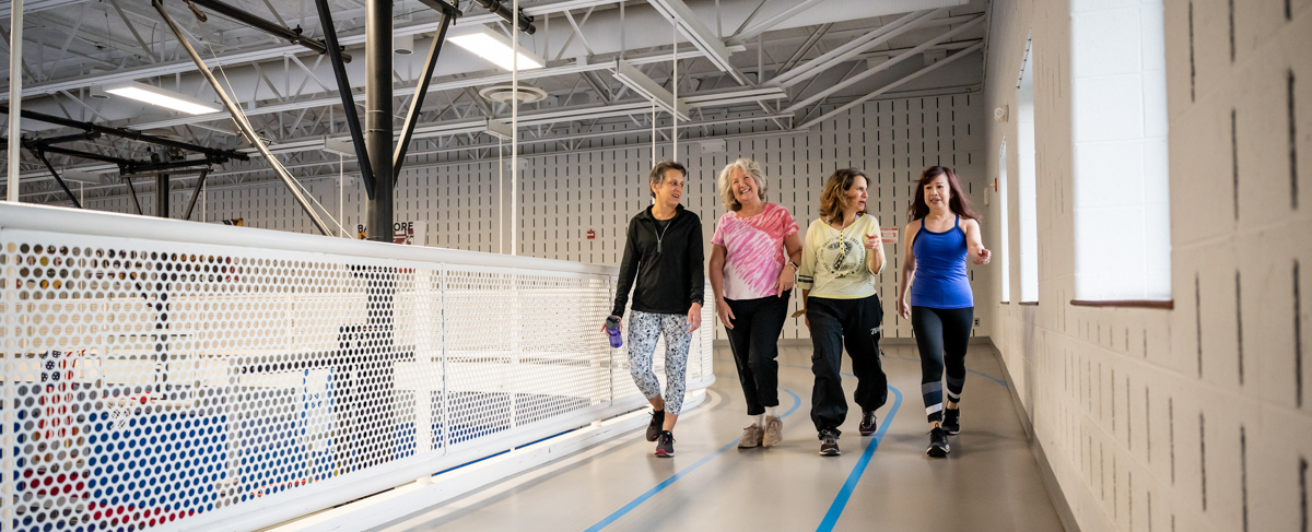 A group of women walking on an indoor track.