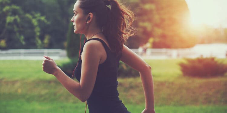 woman jogging in park at sunrise