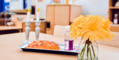 shabbat candles and challah with flowers