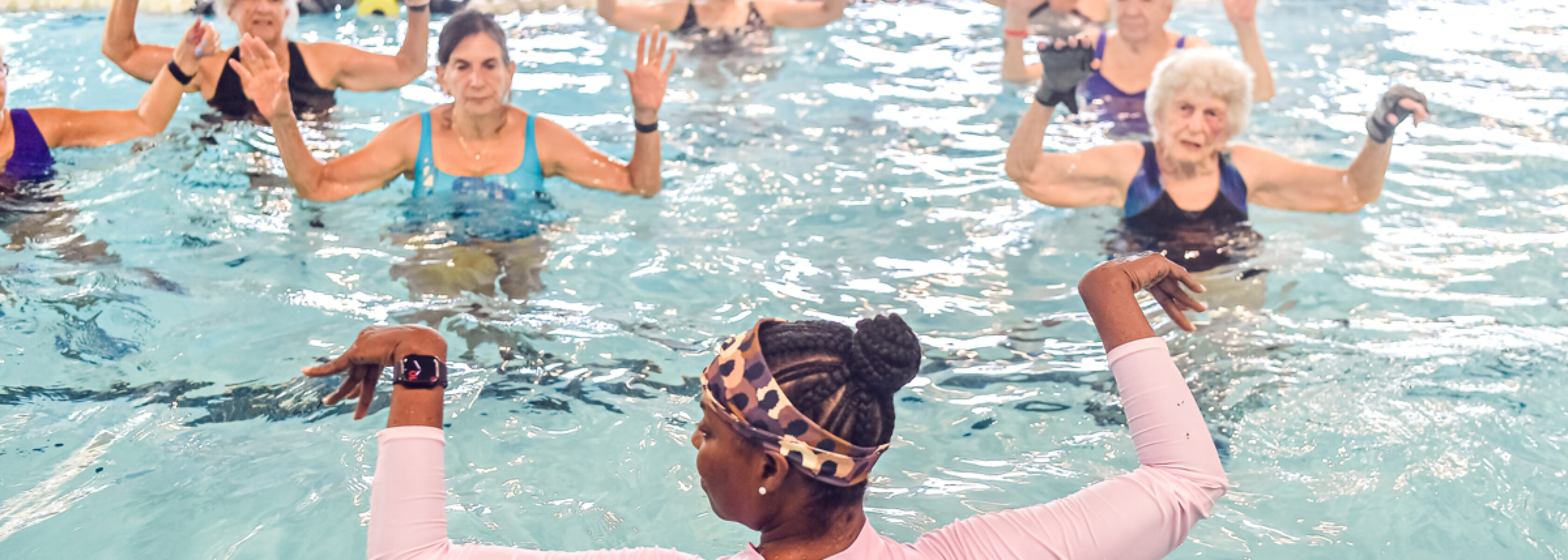 group of women in pool with fitness intructor