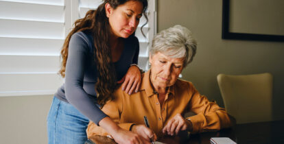 two women planning at desk with paperwork
